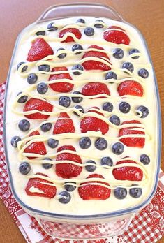 a cake with strawberries and blueberries in it on a red checkered napkin