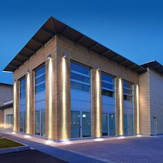 a large building with lights on the side of it's windows at night time