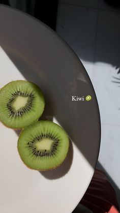 two kiwi slices sitting on top of a white plate