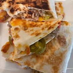 two quesadillas stacked on top of each other with peppers and meat in the middle