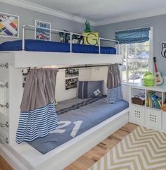 a bunk bed with blue and white decor in a child's playroom or bedroom