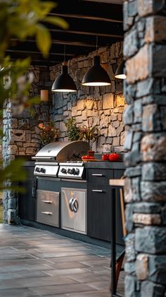 an outdoor kitchen with stone walls and grill