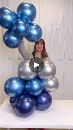 a woman is holding balloons in the air