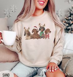 Embrace the spirit of Christmas with our charming Dachshund sweatshirt! This delightful tee combines two of our favorite things: adorable wiener dogs and Christmas. It's the perfect way to show off your love for your favorite dog and celebrate the cozy season. ♥50% cotton, 50% polyester ♥ Medium-heavy fabric ♥Loose fit ♥Sewn-in label ♥Runs true to size PROCESSING TIMES & SHIPPING: During the busy holiday season our processing times can range from 3-5 BUSINESS days + 3-7 days to ship. Please Plan accordingly. CARE INSTRUCTIONS: To ensure the longevity of the design, it is recommended to machine wash the sweatshirt inside out in cold water. Tumble dry on low settings or Hang dry for best care. Do not iron on the design! PAW-SITIVE EXPERIENCE GUARANTEED: All of our items are made to order. If Cat Mom Sweatshirt, Music Cassette, Meowy Christmas, Display Type, Dog Sweatshirt, Mama Shirts, Holiday Sweatshirt, Cat Sweatshirt, Mom Sweatshirt