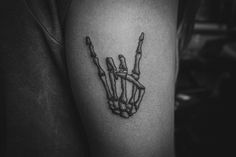 a black and white photo of a person's arm with a skeleton hand tattoo on it