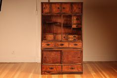 an old wooden cabinet sitting on top of a hard wood floor