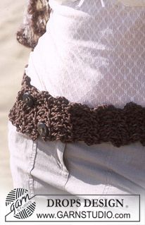 a close up of a person wearing a white shirt and brown crochet belt