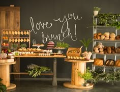 a table filled with cakes and pastries next to a chalkboard that says love you brunch