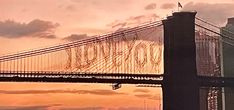 the golden gate bridge in san francisco is lit up at sunset with clouds above it