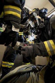 two fire fighters in full gear working on something