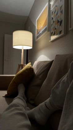 a person laying on a couch under a lamp