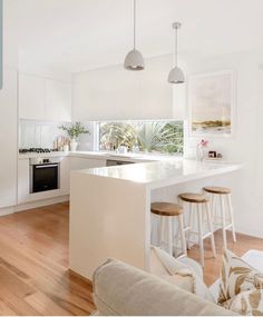 a kitchen with white walls and wooden floors