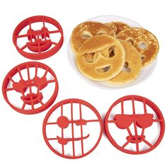 four pancake cutters with mickey mouse faces on them next to a plate of pancakes