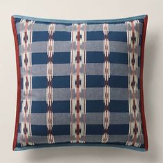 a blue and red pillow on a white wall