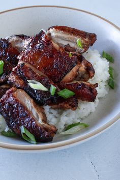 a white plate topped with meat and rice