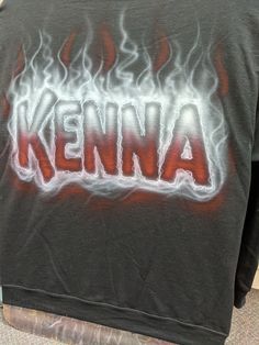 the back of a black shirt with red and white flames on it