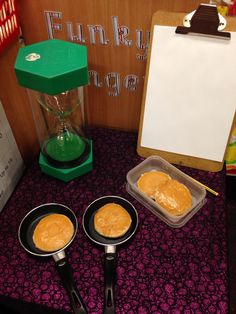 two pans filled with food sitting on top of a table next to a clipboard