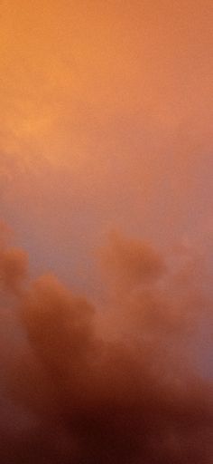 an airplane is flying in the sky at sunset or dawn with orange and pink clouds