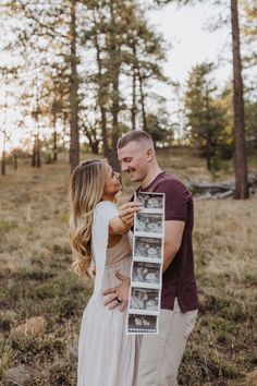 a man and woman standing next to each other in the woods holding an old photo frame