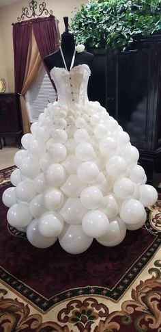 a dress made out of balloons sitting on top of a rug