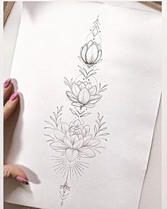 a person is drawing flowers on paper