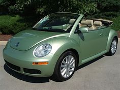 a green convertible car parked in a parking lot