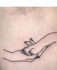 a small tattoo on the side of a woman's stomach with a hand holding a dove