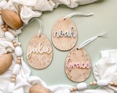 three wooden tags with the words noel, grace and peace hanging from strings on a white background