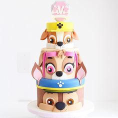 a three tiered cake with dogs on it's sides and eyes painted on the top