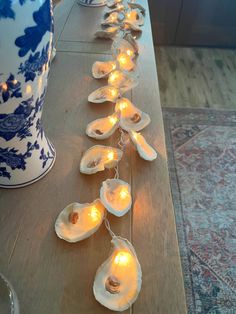 a row of seashells on a table with lights strung down the middle and in between them