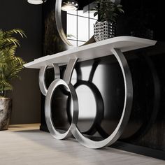 a modern console table with two circular mirrors on it's sides and a potted plant next to it