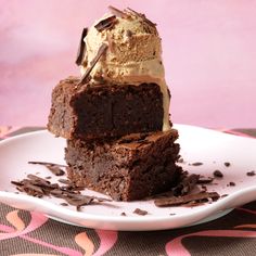 three pieces of chocolate cake on a plate with ice cream and chocolate shavings