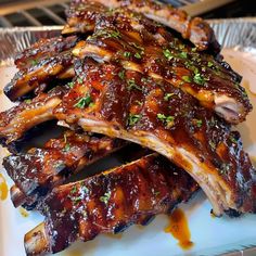 ribs covered in bbq sauce and garnished with parsley on a plate