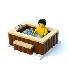 a lego man is sitting in a hot tub filled with water and sodas on the side