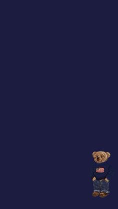 a brown teddy bear standing on top of a blue floor next to an american flag