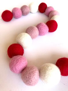 there is a red and white felt ball garland on the table