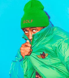 a man wearing a green hat and jacket with the word golf written on it's side