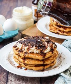 chocolate syrup being drizzled on top of pancakes