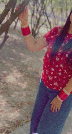 a woman standing in front of a tree holding an umbrella