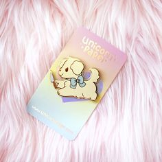 a pin with a dog on it sitting on a pink furry surface