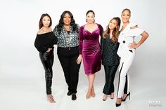 four women standing in front of a white background