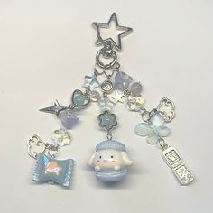 a key chain with charms attached to it on a white surface, including an elephant and other items