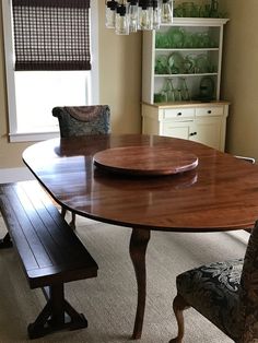 a dining room table and bench in front of a window