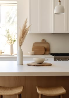 a white kitchen counter with two wooden stools