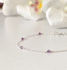 This beautifully simple bracelet is lovingly handmade with a six tiny Amethyst gemstones and a choice of 14k Gold Filled, 14k Rose Gold Filled or Sterling Silver Chain. M A T E R I A L S: * Amethyst * 14k Gold Filled, 14k Rose Gold Filled or Sterling Silver Chain S I Z E: *  Gemstones - Approximately 2-3mm *  Chain Thickness - Approximately 1.1mm  All of our jewellery is carefully handmade using good quality materials and handpicked gemstones, with the aim to produce quality pieces that you can love & wear for years to come.  A M E T H Y S T: * February Birthstone * Talisman for Virgo, Sagittarius, Capricorn, Aquarius, Pisces * Third Eye Chakra, Crown Chakra Amethyst, the birthstone of February, is a powerful and protective stone. Amethyst is a natural tranquiliser, it relieves stress and Dainty Stackable Crystal Bracelet For Gift, Dainty Stackable Crystal Bracelet Gift, Delicate Silver Bracelets With Ethical Gemstones, Dainty Sterling Silver Bracelets With Natural Stones, Delicate Amethyst Jewelry For Gifts, Dainty Stackable Sterling Silver Bracelet As Gift, Dainty Sterling Silver Bracelet With Gemstone, Dainty Sterling Silver Crystal Gemstone Bracelet, Dainty Sterling Silver Gemstone Crystal Bracelet