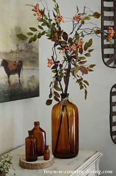 there is a vase with flowers in it and two bottles on the table next to it