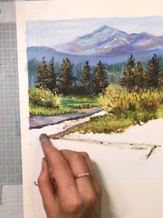 someone is drawing a landscape with watercolors on paper