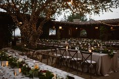 an outdoor dining area with tables and chairs set up for a formal function at dusk