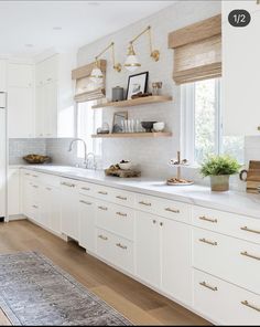 the kitchen is clean and ready to be used for cooking or baking, with white cabinets and gold pulls