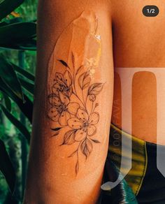 a woman's arm with a flower tattoo on the left side of her body